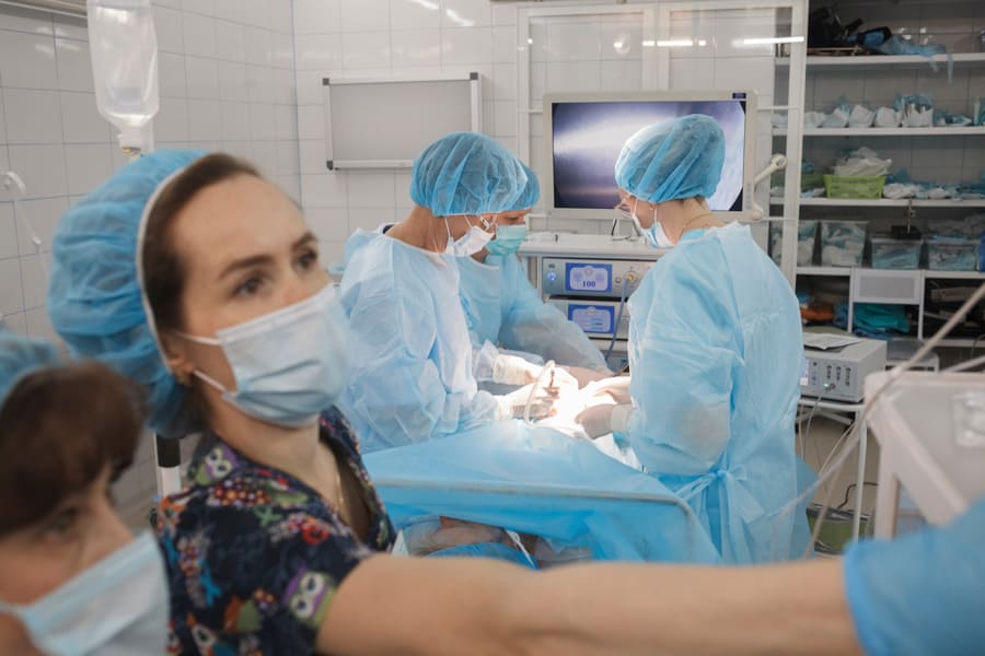 Анестезиолог наблюдает за жизненными показателями пациента во время лапароскопической операции в Клинике Санитас